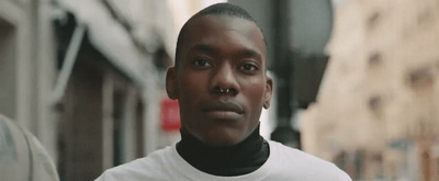 a man in a white shirt standing on a city street