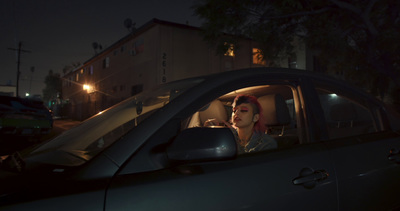 a woman sitting in a car at night