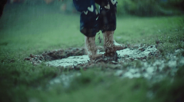 a person walking through a puddle in the grass