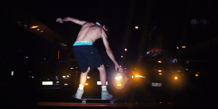 a man riding a skateboard down a street at night