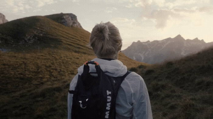 a person with a backpack walking up a hill