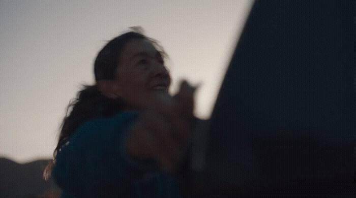 a woman holding a cell phone up in the air