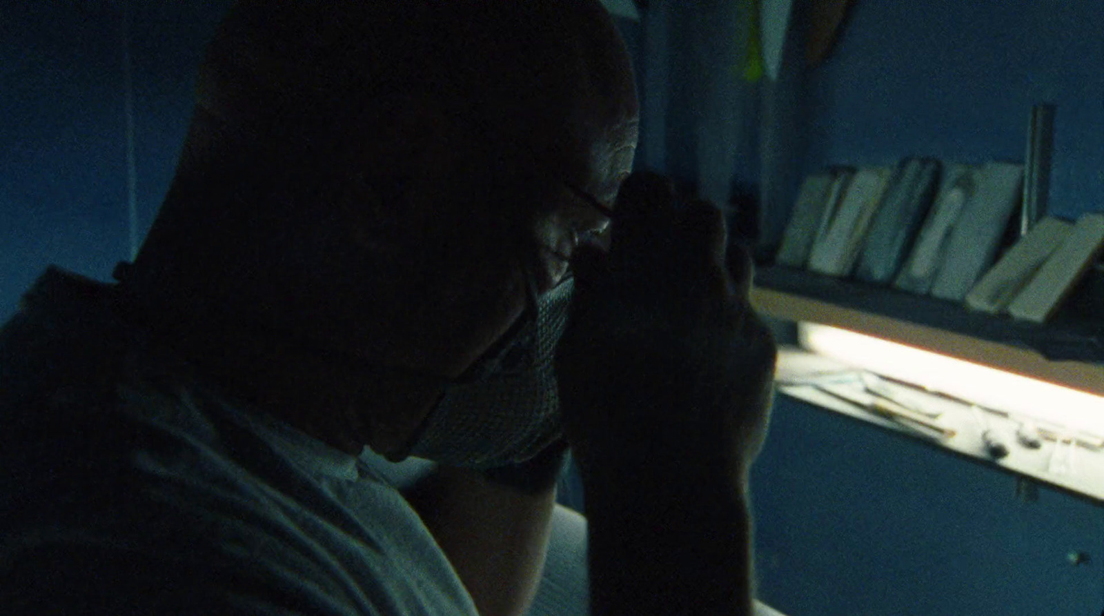 a man in a dark room looking at his cell phone