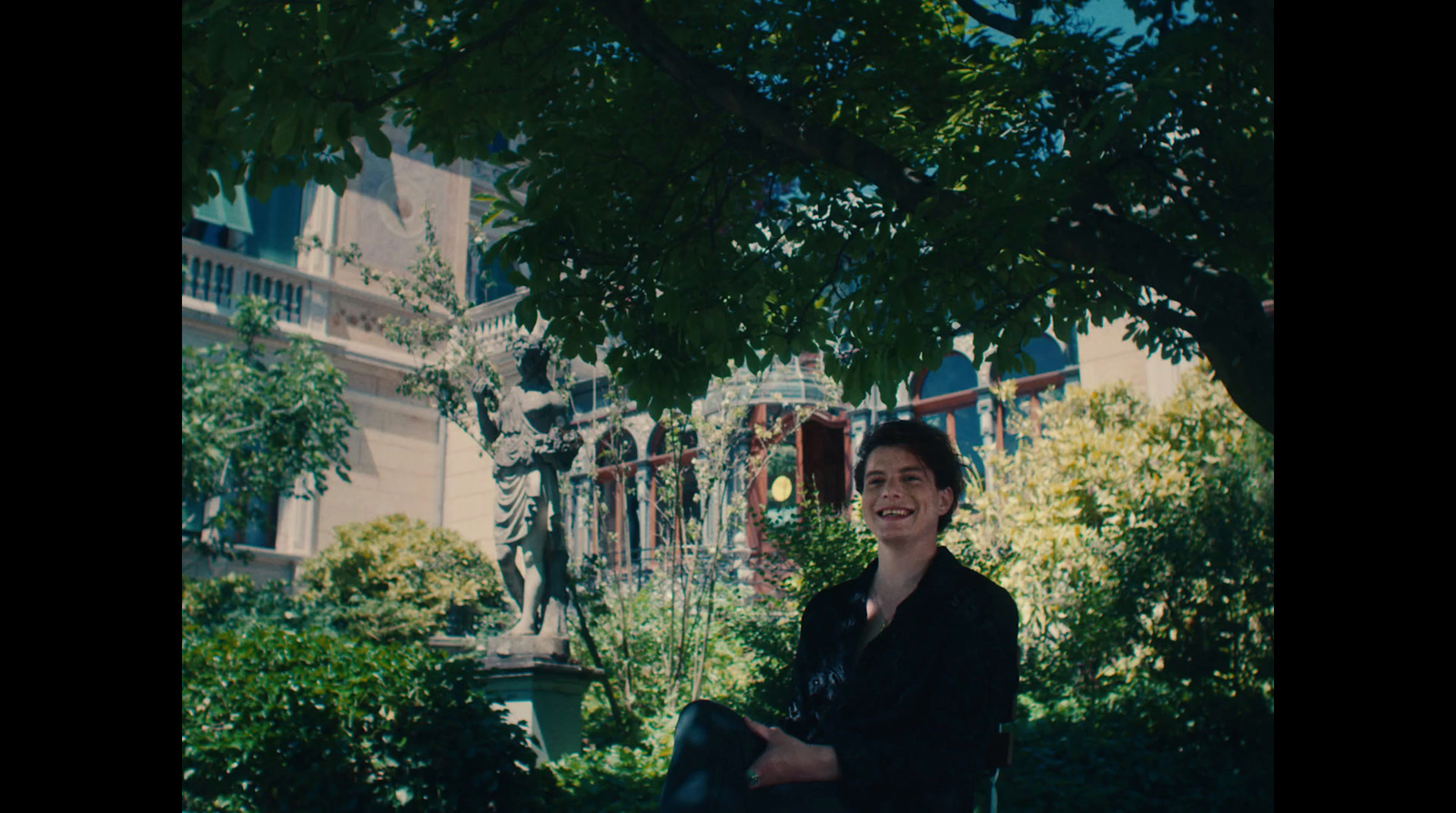 a woman sitting on a bench under a tree