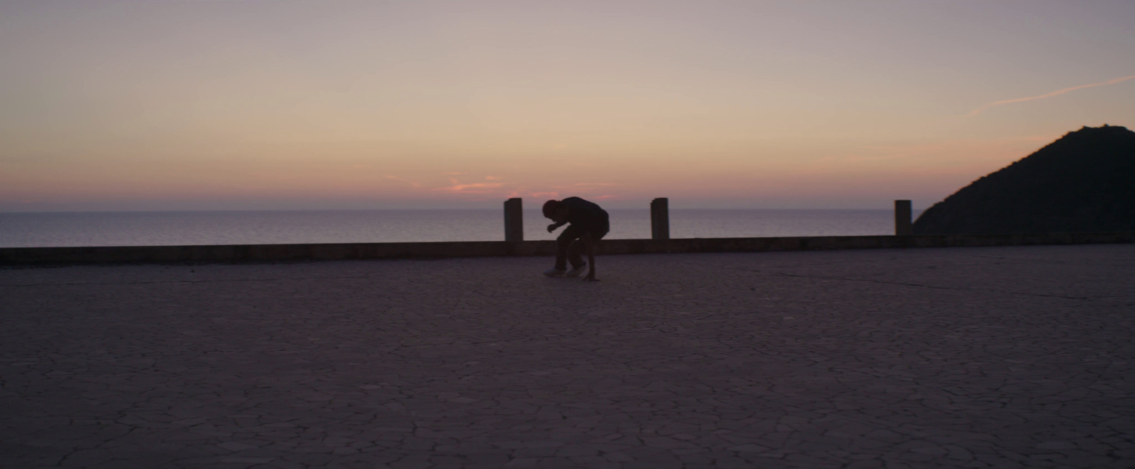 a man standing on top of a sidewalk next to the ocean