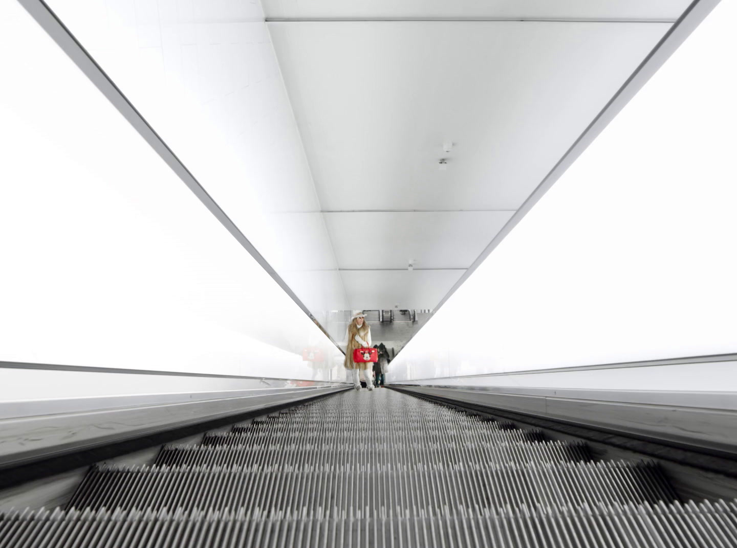 a couple of people walking down a long hallway