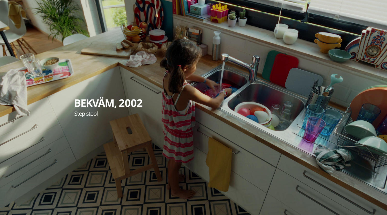 a little girl washing dishes in a sink