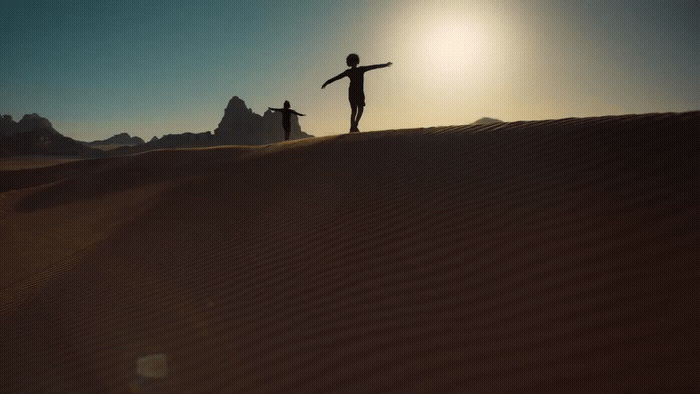 a couple of people that are standing in the sand