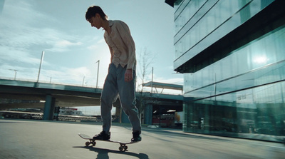 a man riding a skateboard down a street next to a tall building