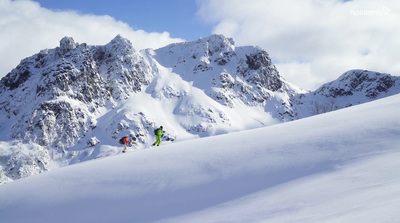 a group of people riding skis down a snow covered slope