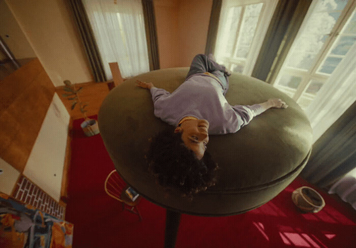 a woman laying on top of a green chair