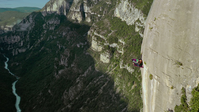 a person on a cliff with a paraglider