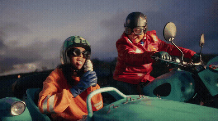 a man and a woman riding on the back of a motorcycle