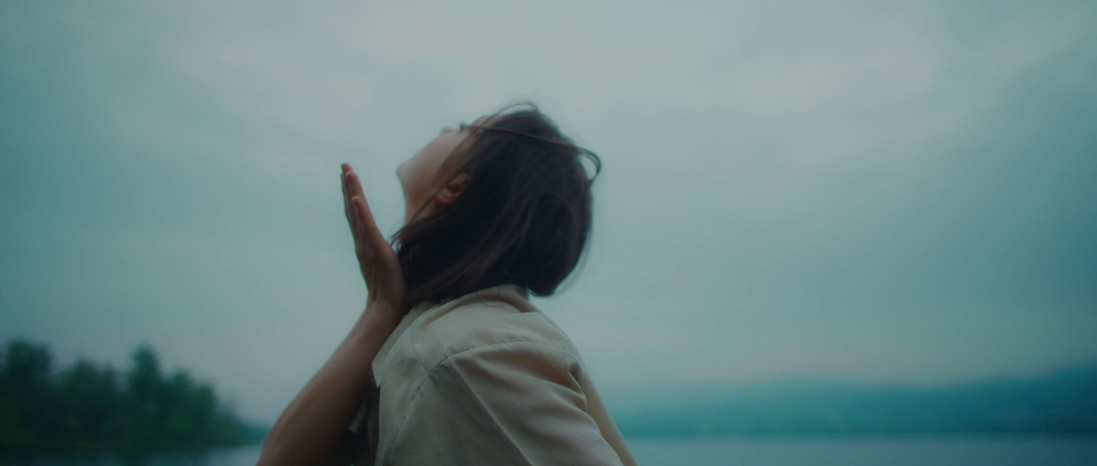 a woman standing in front of a body of water