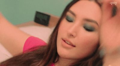 a woman in a pink shirt holding a cell phone