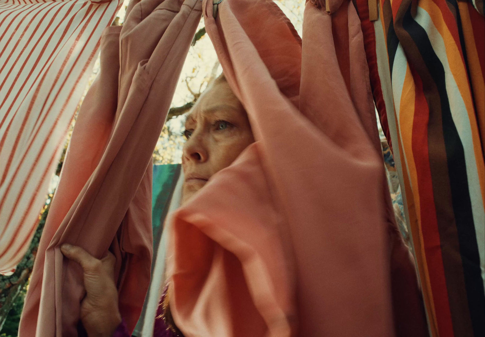 a woman peeking out from behind a curtain