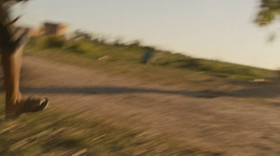 a blurry photo of a person walking down a dirt road