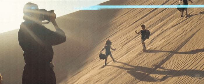 a group of people standing on top of a sandy beach