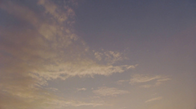 a group of people standing on top of a beach under a cloudy sky