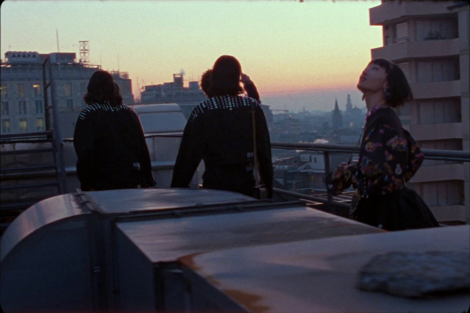 a group of people standing on top of a building