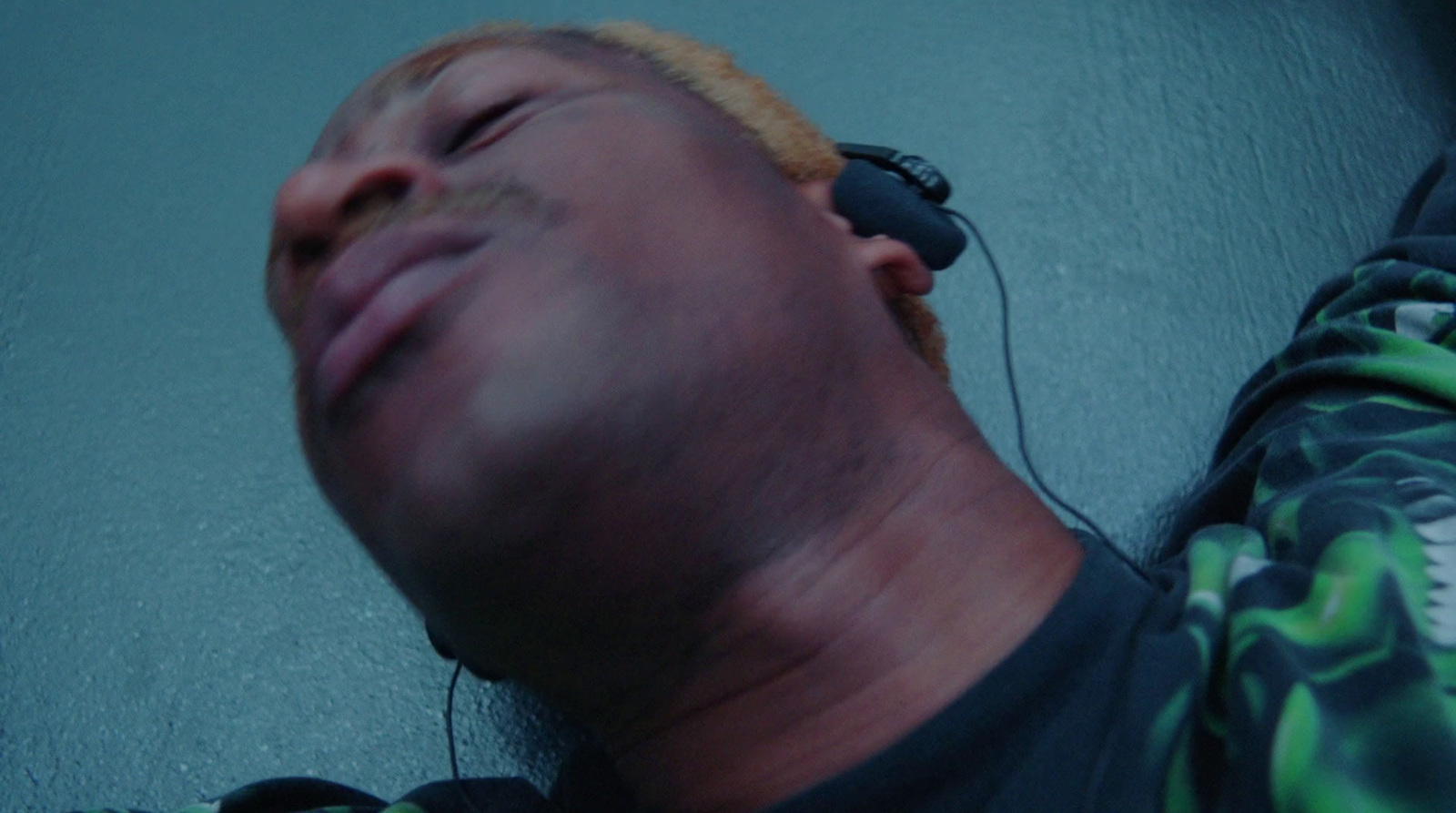 a man with headphones laying on the ground