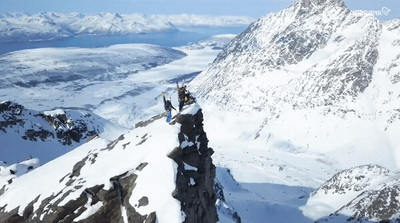 a group of people standing on top of a snow covered mountain