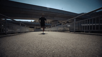 a man running across a bridge in a black shirt