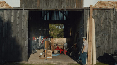 a man standing in the doorway of a barn