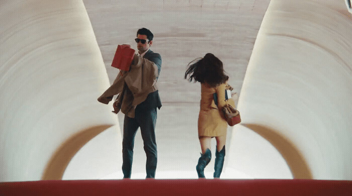 a man and a woman walking through a tunnel