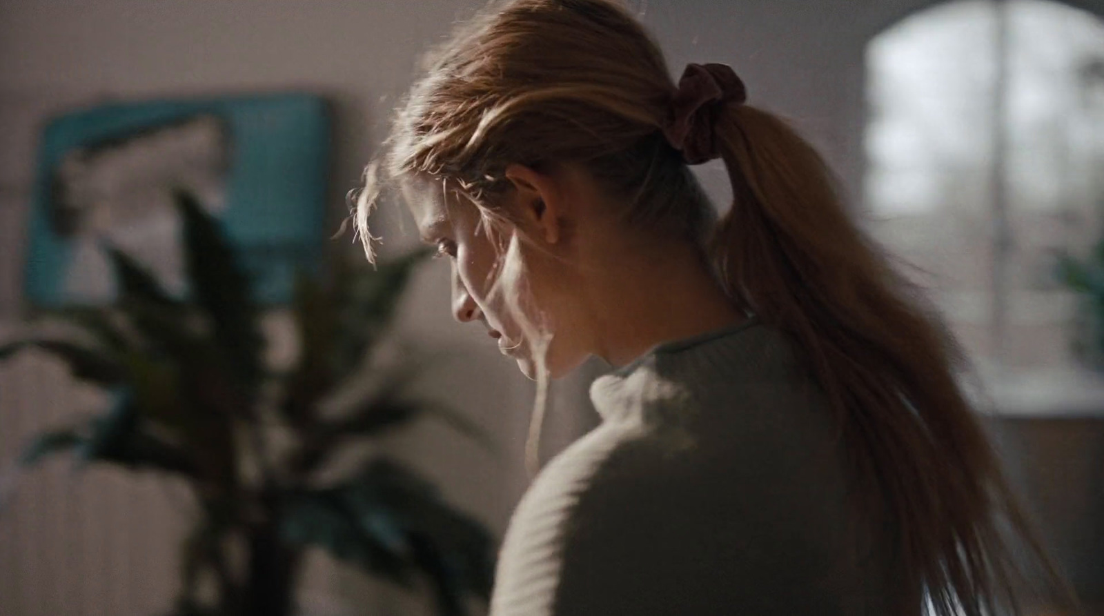 a woman with a ponytail standing in a room