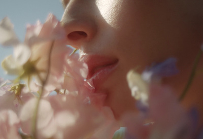 a close up of a woman's face and flowers