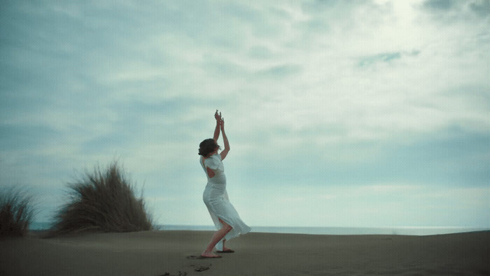 a woman standing on top of a sandy beach