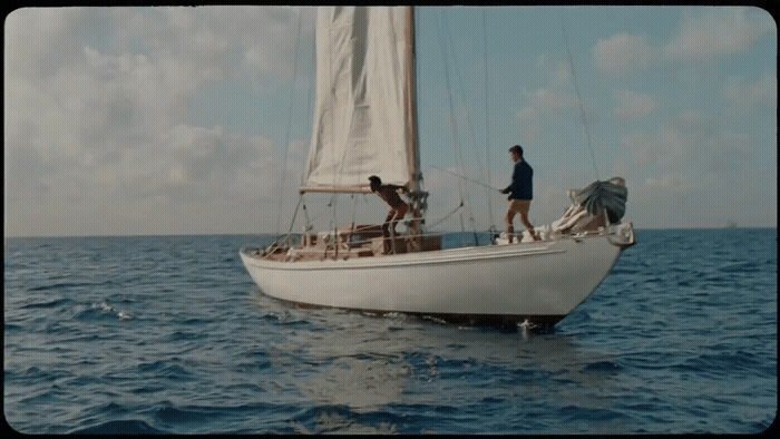 a couple of people on a sailboat in the water