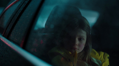 a little girl sitting in a car looking out the window