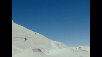 a man riding skis down the side of a snow covered slope