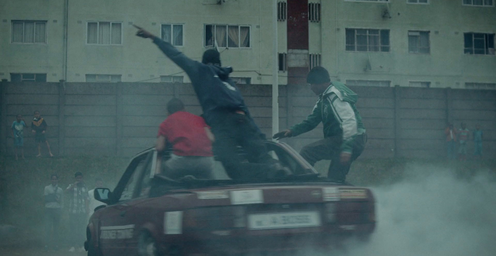 a group of people standing on top of a car