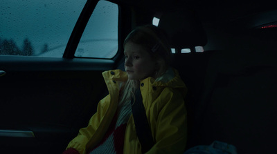 a little girl sitting in the back seat of a car