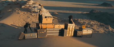 a pile of luggage sitting on top of a sandy beach