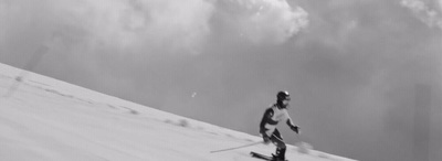 a man riding skis down a snow covered slope