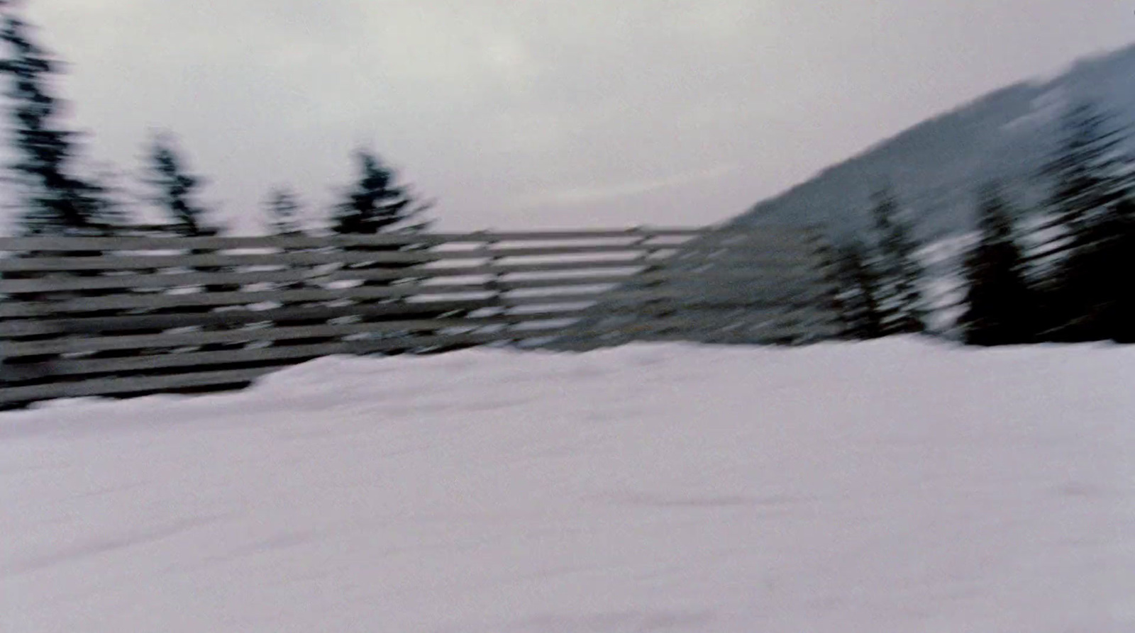 a man riding a snowboard down a snow covered slope