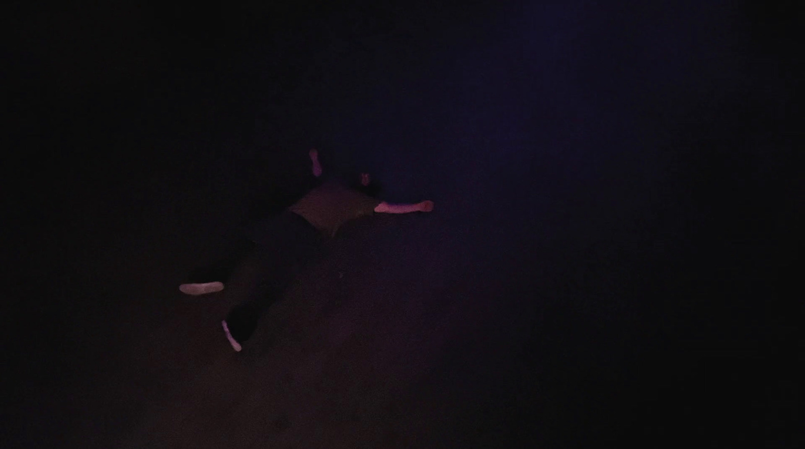 a person laying on the ground in the dark