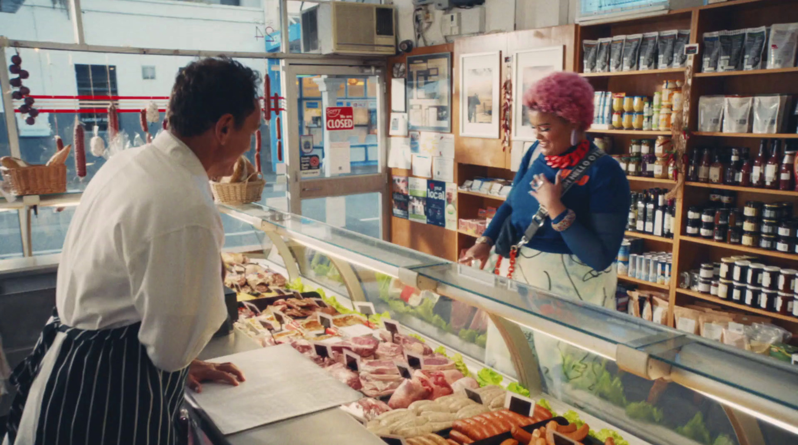 a man and a woman standing in front of a display of food