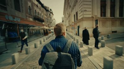 a man with a backpack is walking down the street