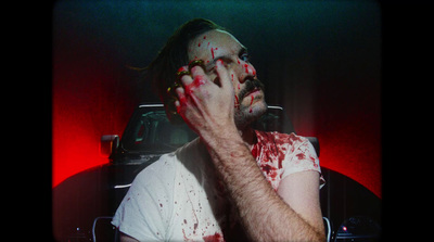 a man with blood all over his face and hands