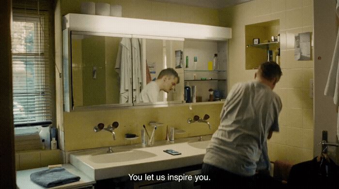 a man standing in front of a bathroom mirror