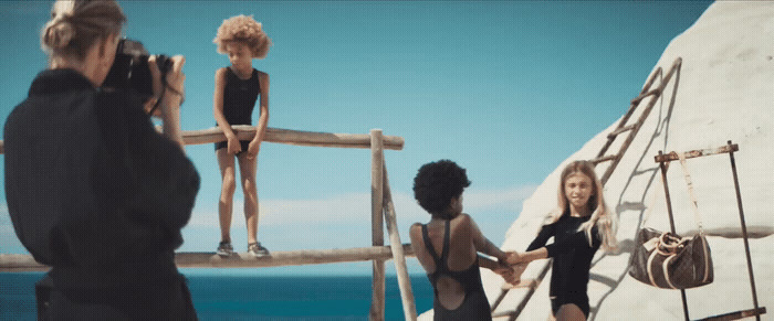 a group of women standing on top of a wooden bridge