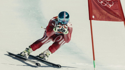 a man riding skis down a snow covered slope