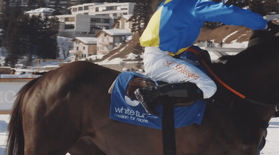 a man riding on the back of a brown horse