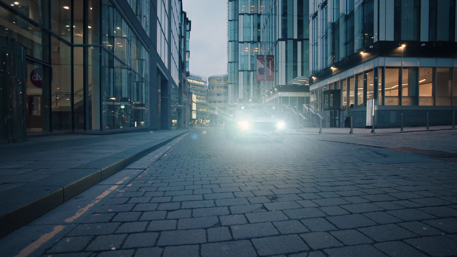 a car driving down a street next to tall buildings