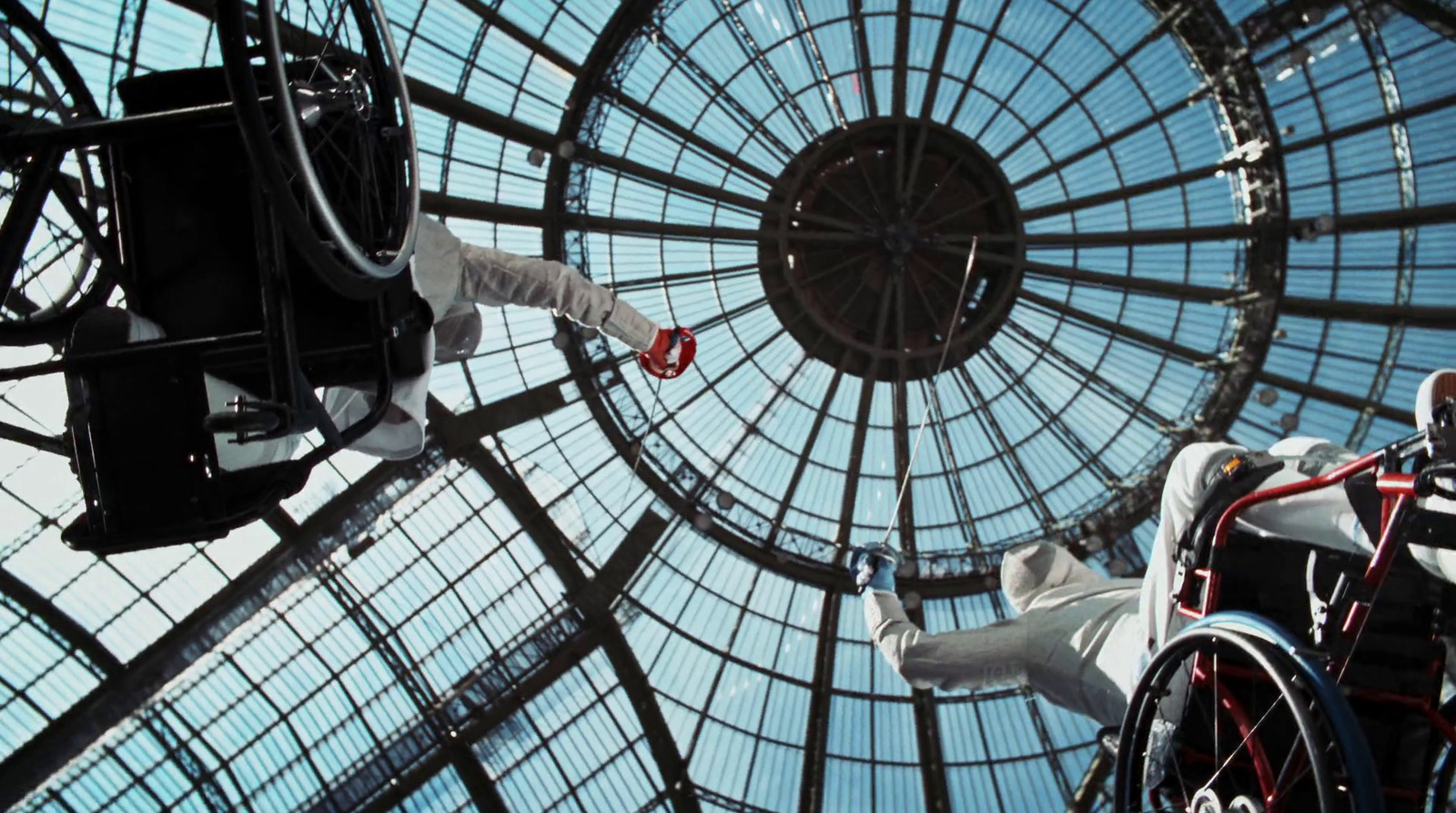 a man in a white suit is suspended from a glass ceiling